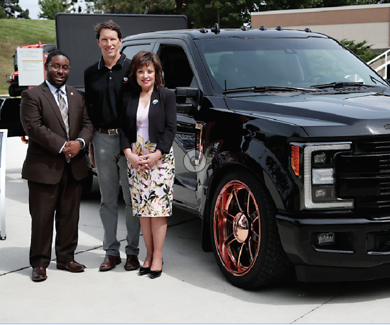 Extang Vice President of of Sales Steve Kelley (center) poses with WCC President Dr. Rose B. Bellanca and Dean of Advanced Technologies & Public Service Careers Brandon Tucker alongside the “Ultimate Tailgate Truck” that WCC students and faculty customized for the Ann Arbor-based manufacturer of truck bed accessories.